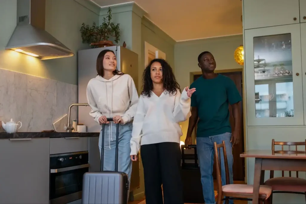 Three travelers inspecting an Airbnb kitchen upon arrival