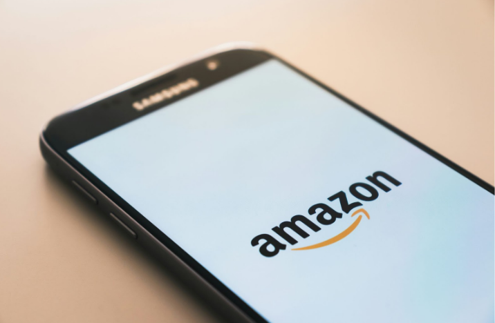 Smartphone displaying Amazon logo on the screen, placed on a flat surface