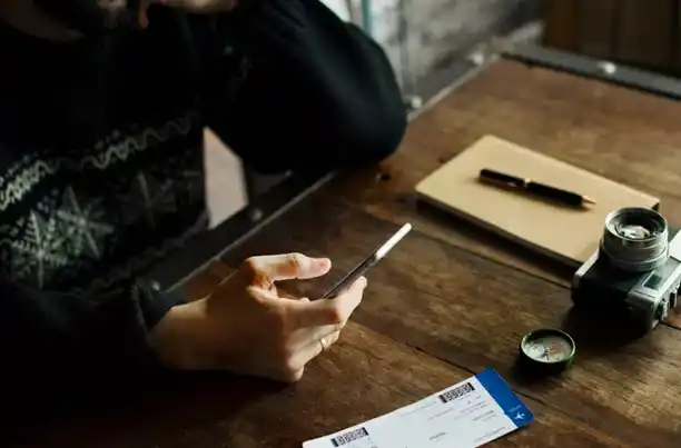 Man on the phone with tickets on the table, possibly dealing with Ticketmaster scams