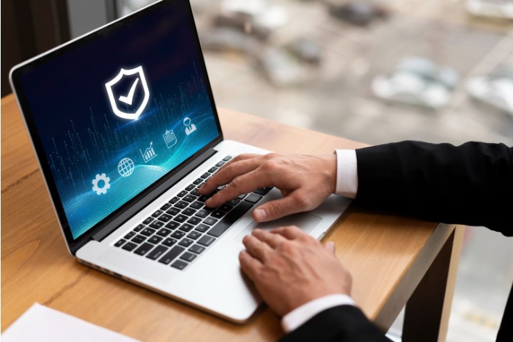 Person working on a laptop with a digital security screen, representing concerns about data privacy and trust in new AI technologies